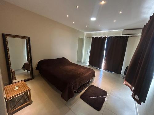 a bedroom with a bed and a large mirror at Casa temporada Cabo Frio Casa pôr do Sol in Cabo Frio
