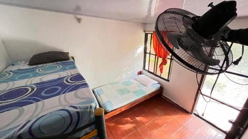 a small room with a bed and a fan at CABAñA EDEN in Santa Marta
