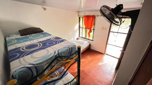 a small bedroom with a bed and a window at CABAñA EDEN in Santa Marta