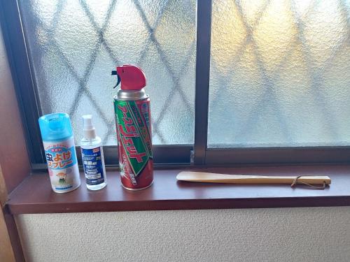 a window sill with a bottle of hot sauce and a knife at ビーチまで徒歩5分 BBQ無料 7名迄OK 戸建て貸切宿 Bignet villa in Miyamae
