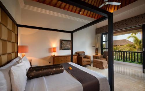 a bedroom with a large bed and a living room at The Residence Seminyak in Seminyak