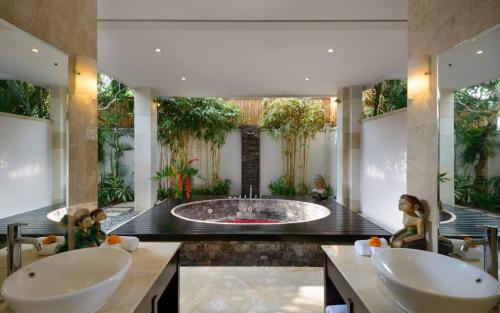 a bathroom with two sinks and a large tub at The Residence Seminyak in Seminyak
