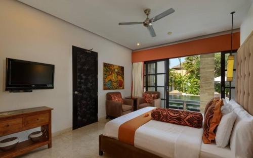 a bedroom with a bed and a flat screen tv at The Residence Seminyak in Seminyak