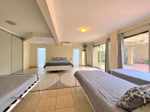 a large room with two beds and a couch at The Sandcastle in Burrum Heads