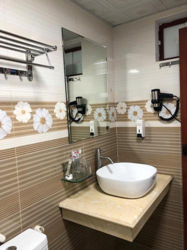 a bathroom with a sink and a mirror at Quoc Thai Sapa Hotel in Sapa