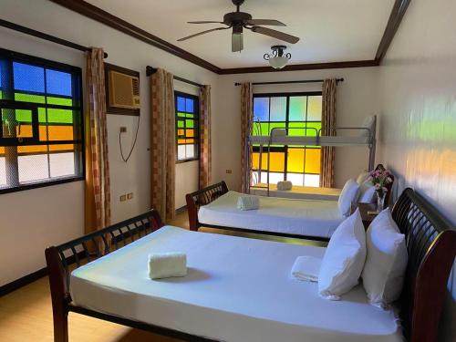 two beds in a room with stained glass windows at Club Balai Isabel - Villa Arra in Talisay