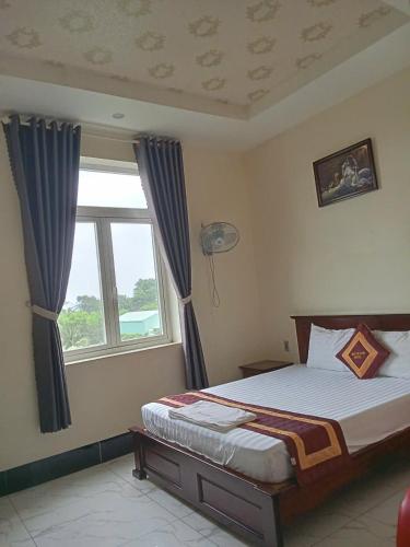 a bedroom with a bed and a window at Trúc Huỳnh Hotel Tây Ninh in Tây Ninh