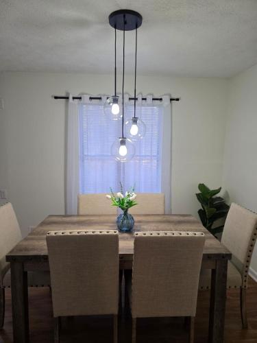 a dining room table with chairs and a vase of flowers at Charming 3 bedrooms in the heart of Alpharetta in Alpharetta