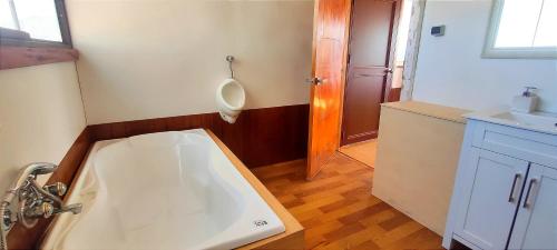 a bathroom with a sink and a urinal on the wall at Titicaca Halso Lodge in Puno