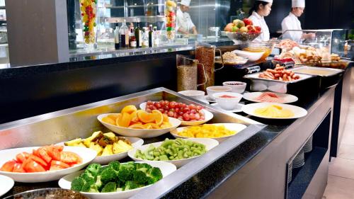 a buffet line with many bowls of fruits and vegetables at RIHGA Royal Hotel Osaka, Vignette Collection by IHG in Osaka