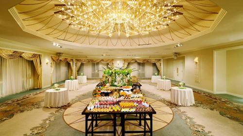 a banquet hall with tables with food and a chandelier at RIHGA Royal Hotel Osaka, Vignette Collection by IHG in Osaka