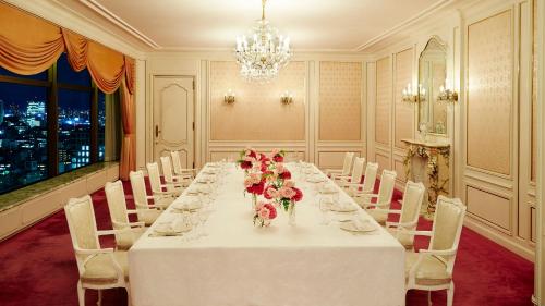 a dining room with a long table with flowers on it at RIHGA Royal Hotel Osaka, Vignette Collection by IHG in Osaka