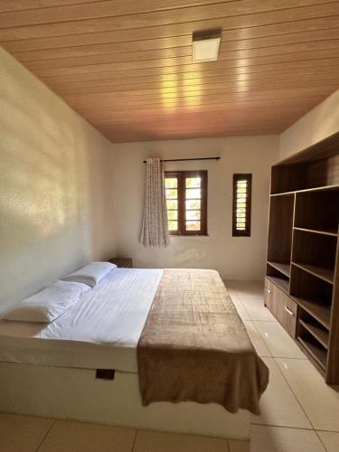 a bedroom with a large bed with a wooden ceiling at Sítio Barra - Suíte Privada Independente 1 in Guaramiranga