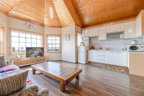 a living room with a table and a kitchen at Ganghwa Western Beach Pension in Incheon
