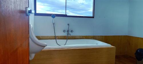 a bath tub in a bathroom with a window at Titicaca Halso Lodge in Puno