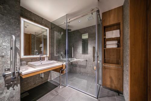 a bathroom with a sink and a shower at Sotetsu Grand Fresa Bangkok in Bangkok
