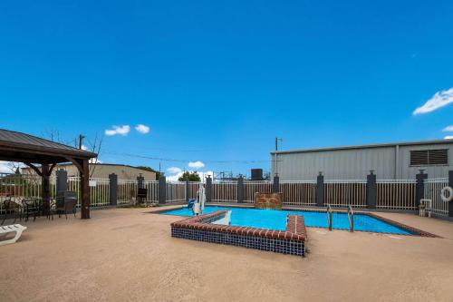 a swimming pool in a yard with a fence at Rodeway Inn & Suites Corpus Christi Northwest in Corpus Christi