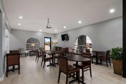 a dining room with tables and chairs and a tv at Rodeway Inn & Suites Corpus Christi Northwest in Corpus Christi