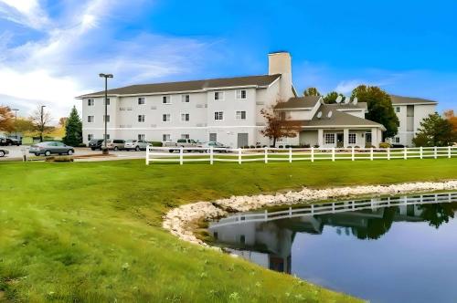 a large white building with a pond in front of it at Rodeway Inn Fishers Indianapolis in Fishers