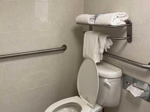 a bathroom with a toilet with towels on a rack at Prado Hotel by Choice Hotels in Ridgeland