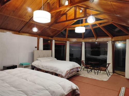 a bedroom with two beds and a table and chairs at Titicaca Halso Lodge in Puno