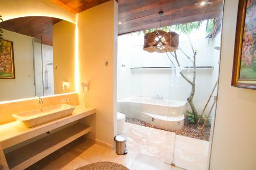 a bathroom with a tub and a sink at Ubu Villa Sujiva in Ngaglik