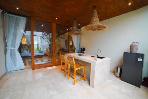 a kitchen with a counter with chairs and a sink at Ubu Villa Sujiva in Ngaglik