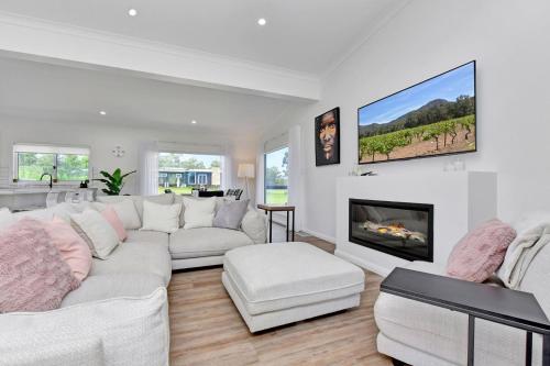 Una sala de estar con un sofá blanco y una chimenea. en Magpie Three- Two for Joy Estate. 2.5 Bathrooms sleeping 6, en Greta