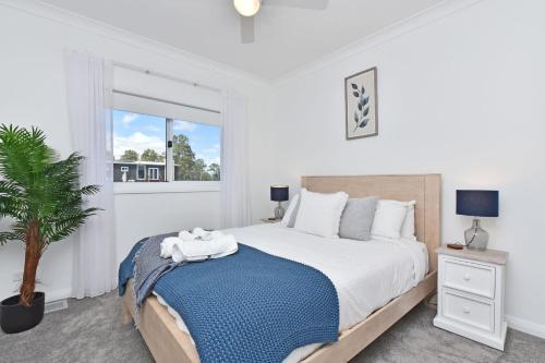 GretaMagpie Three- Two for Joy Estate. 2.5 Bathrooms sleeping 6的白色卧室设有一张大床和一棵棕榈树