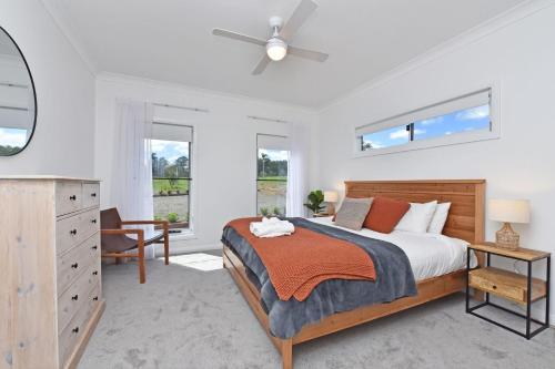 Un dormitorio con una cama, una cómoda y ventanas. en Magpie Three- Two for Joy Estate. 2.5 Bathrooms sleeping 6, en Greta