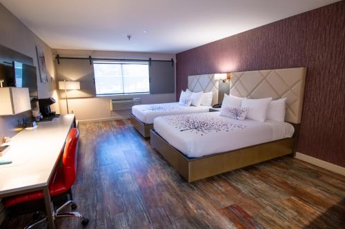 a hotel room with two beds and a desk at Empeiria High Sierra Hotel in Mammoth Lakes