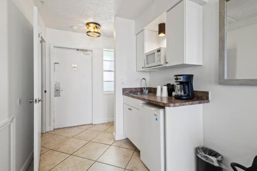 a kitchen with white cabinets and a counter top at Oceanfront Inn Room #25- Ocean View Balcony King Bed in Fort Pierce