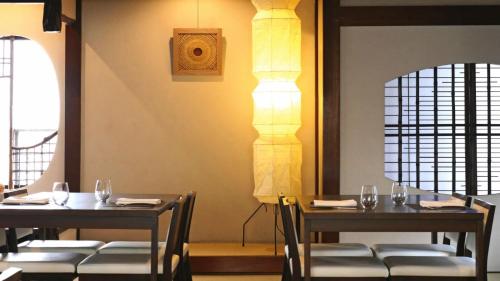 a dining room with two tables and a lamp at NIPPONIA HOTEL Takehara Saltworks Town in Takekara
