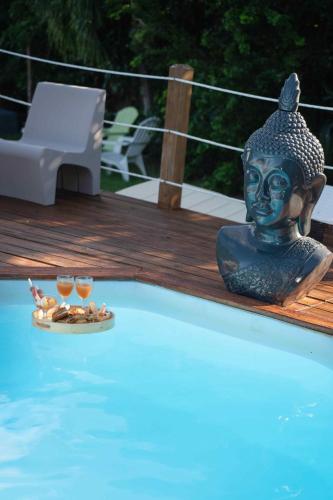 a statue sitting in a pool with two glasses of wine at Exotic Villa avec Piscine in Le Vauclin