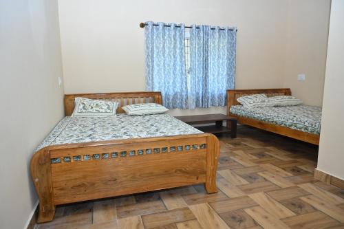 a bedroom with two beds and a window at Bhuvi farm & homestay in Channapatna