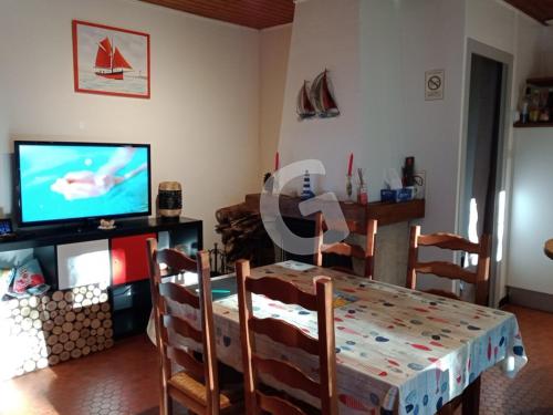 une salle à manger avec une table et une télévision dans l'établissement Pavillon 4 pers au cœur d'un parc à Jard-sur-Mer - FR-1-357-336, à Jard-sur-Mer