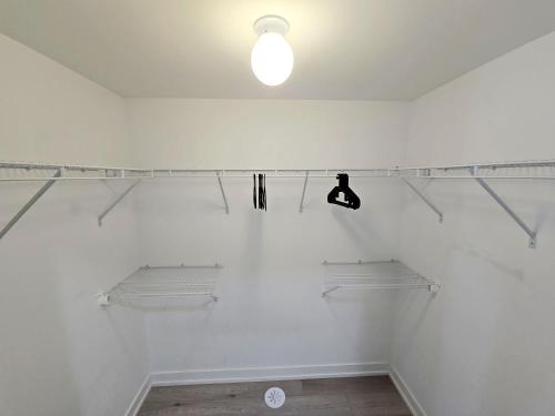 a white room with shelves and a light on the wall at King Bed TV Private Ensuite Retreat Bathroom or Economical Double Bed Room in Toronto