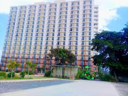 a large building with a playground in front of it at Cebu stays-Saekyung 956 Condominium unit 1209 in Lapu Lapu City