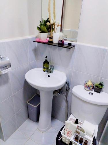 a white bathroom with a sink and a toilet at Cebu stays-Saekyung 956 Condominium unit 1209 in Lapu Lapu City