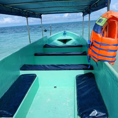 a green boat with seats in the water at Renata Cottages in Ohoililir