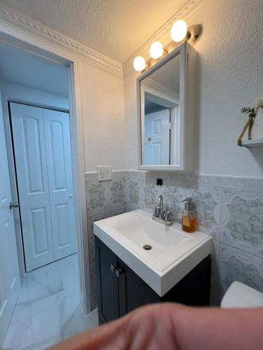a bathroom with a white sink and a mirror at AMIRI Hollywood 5 mins from Hard Rock Stadium & The Guitar in Hollywood