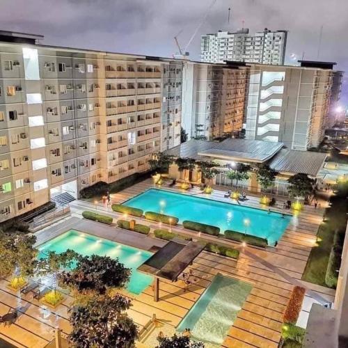 an overhead view of a building with a swimming pool at 1-bedroom Condo Unit with PS5, Netflix & Pool near SM Fairview in Manila