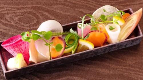 a wooden tray filled with different types of vegetables at NIPPONIA HOTEL Takehara Saltworks Town in Takekara