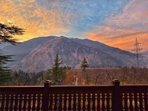 a view of a mountain at sunset from a fence at Hygge Home Manali in Manāli