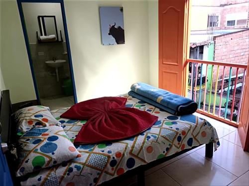 a bed with a comforter and pillows on it at DESCANSO DEL ARRIERO - Su Mejor Descanso en Guatapé in Guatapé