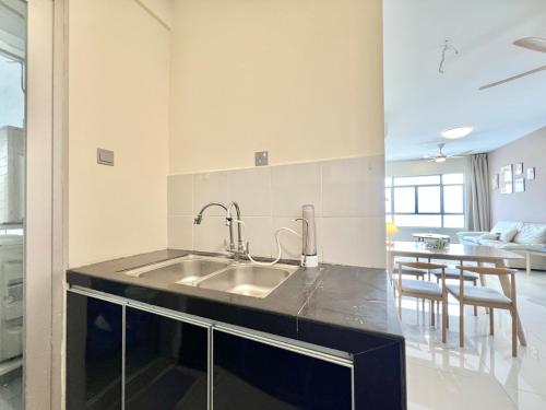 a kitchen with a sink and a living room at Perling Muji 3 Bedrooms Suites 6 pax Paradigm Mall in Johor Bahru