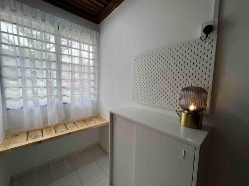 a room with a window and a table with a lamp at Cosy Pinewood House 5 Pax- Family friendly, Wifi in Kajang