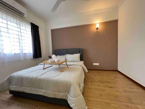 a bedroom with a bed with a table on it at Cosy Pinewood House 5 Pax- Family friendly, Wifi in Kajang