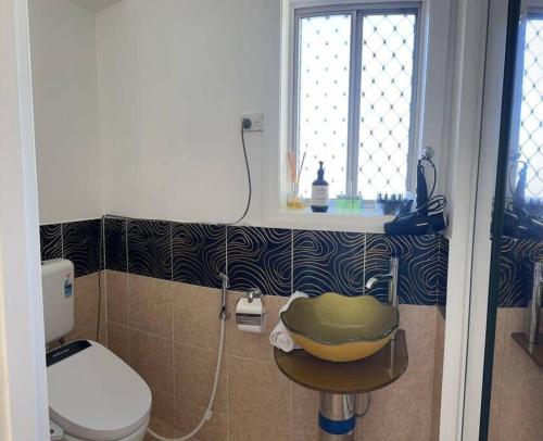 a bathroom with a sink and a toilet and a window at Studio house Unit in Dundas Valley in Sydney