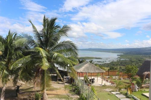 a view of the water from a resort with a palm tree at Casa De Amor Lambug in Badian